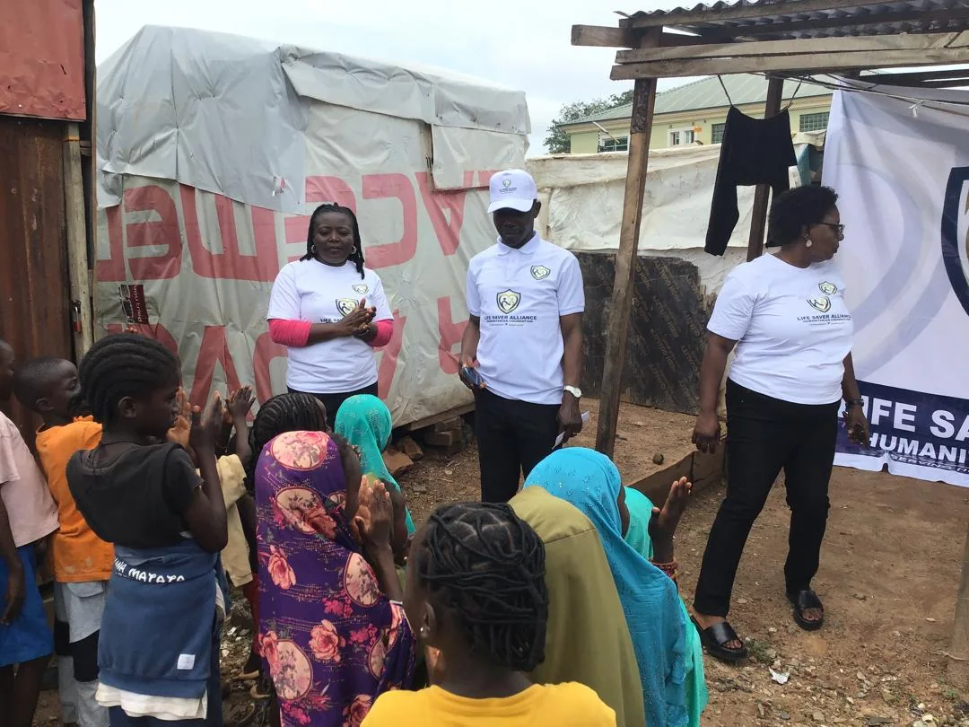LAHF volunteers address children gathered at the Crown Court Estate IDP camp