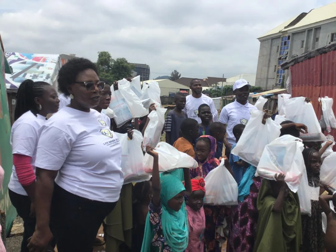 LAHF volunteers and children gather with relief packages in the camp