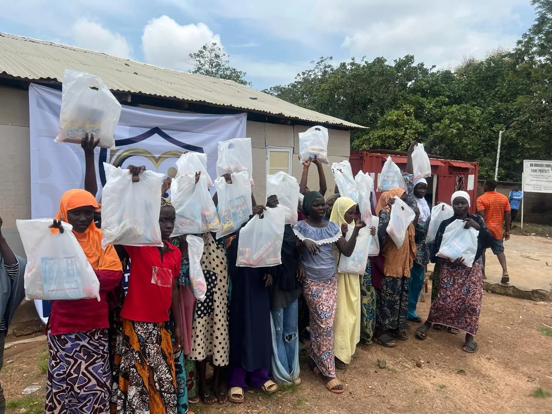 Community members display relief packages with LAHF volunteers after the Durumi 1 distribution
