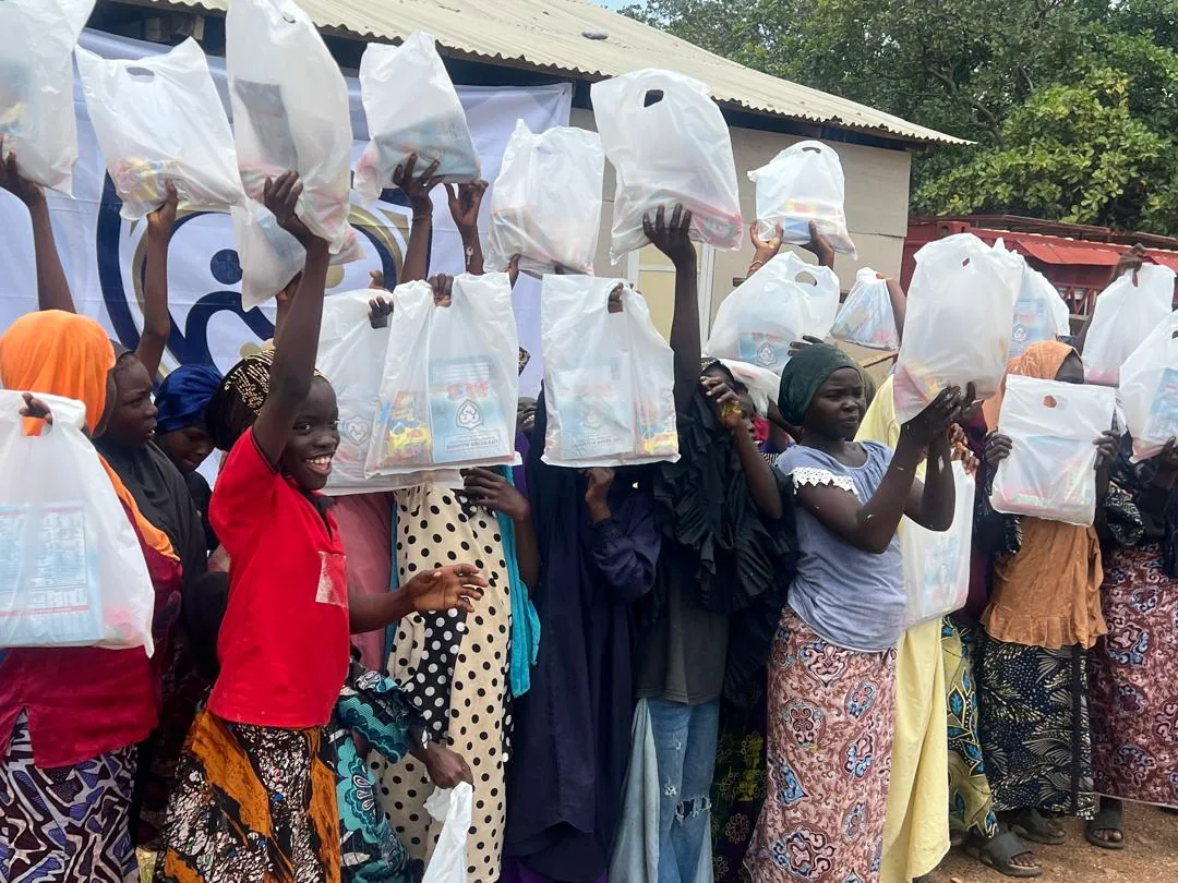 Community members display relief packages with LAHF volunteers after the Durumi 1 distribution